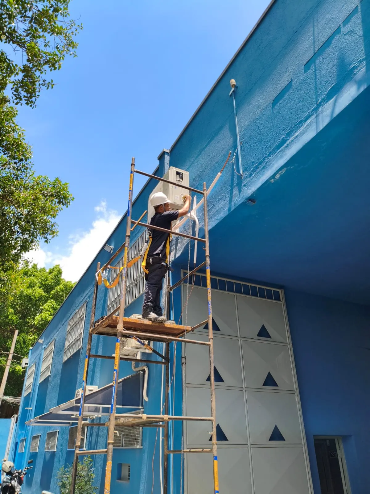 Instalador de Ar condicionado pindurando condensadora