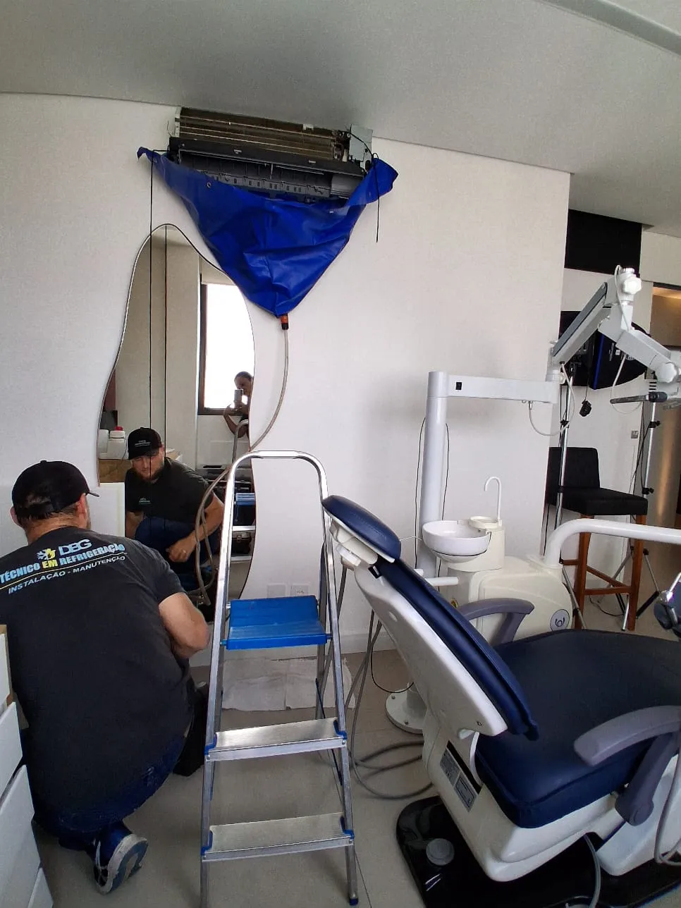técnico da dbg ar-condicionado realizando limpeza de evaporadora em clínica de são paulo